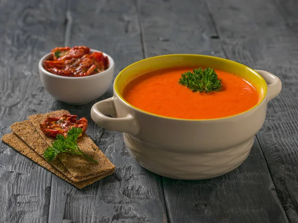 Soup mashed vegetables and dried tomatoes with bread toast on a wooden table. — Stock Photo, Image