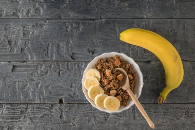 Muz ve bir fincan kinoa ve kakao lapası ahşap bir masada..