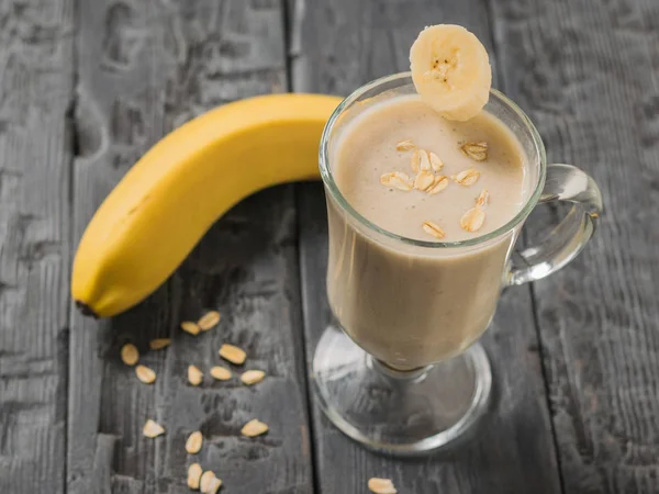 Sepotong pisang dalam gelas dengan smoothie pisang. Vegetarian smoothie . — Stok Foto