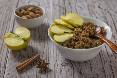 Taze elma, kinoa lapası ve tahta bir masada kakao..
