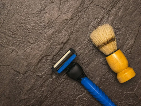 Navaja azul para hombre y cepillo de afeitar sobre un fondo de piedra. Puesta plana . — Foto de Stock