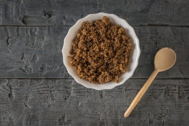 Kakao ve kakao lapası dolu beyaz bir kasenin yanında tahta kaşık. Düz yatıyordu.