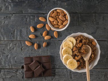 Çikolata, dağınık badem ve kinoa lapası ahşap bir masada. Düz yatıyordu.