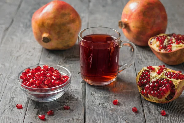 Fruits de grenade mûrs et jus de grenade frais sur une table en bois . — Photo