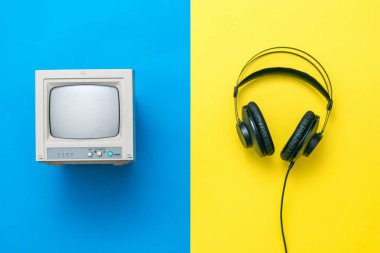 Sarı ve mavi arka planda siyah kulaklıklar ve Retro monitör.