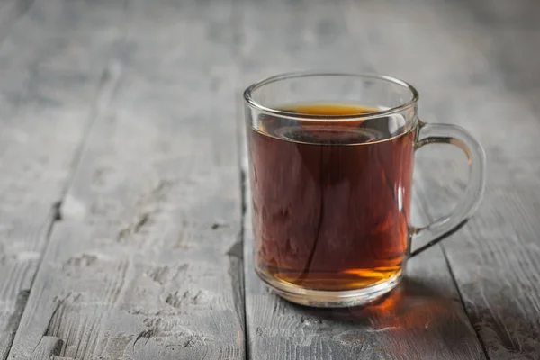 Tasse en verre avec boisson aux herbes sur une table rustique noire . — Photo