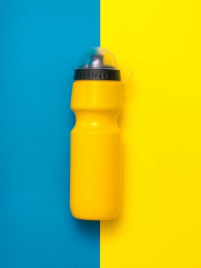 Sarı ve mavi kapaklı sarı spor şişesi.