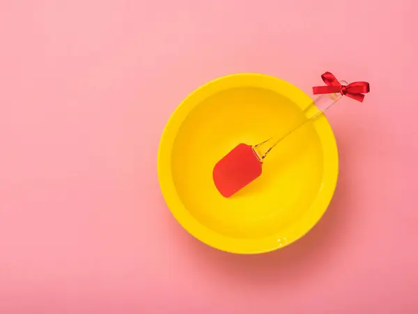 Pala de cocina en un tazón amarillo sobre un fondo rosa. Puesta plana . — Foto de Stock