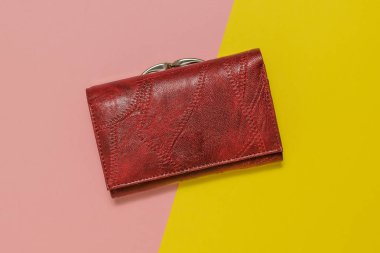 Sarı ve pembe arka planda koyu Burgundy rengi bir kadın çantası..