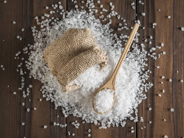 En tygpåse med utspritt salt och en träsked på bordet. — Stockfoto