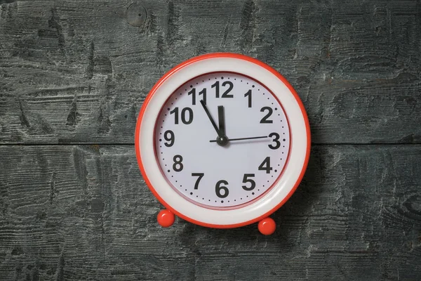 นาฬิกาปลุกสีแดงสดใสบนพื้นหลังไม้ . — ภาพถ่ายสต็อก