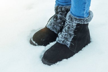 Karda, sıcak botların içinde kadın ayakları.