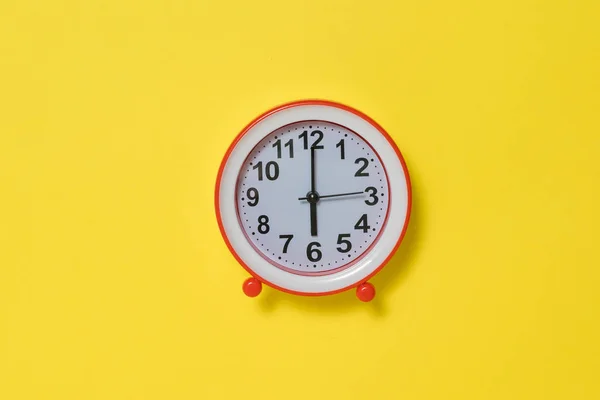 นาฬิกาปลุกสีแดงบนพื้นหลังสีเหลืองสดใส . — ภาพถ่ายสต็อก