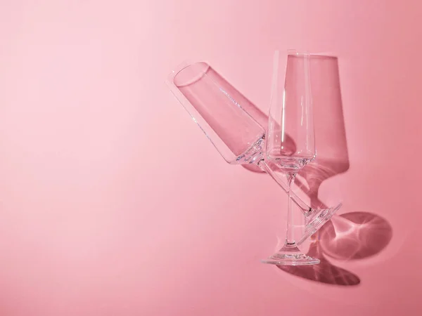 Dos vasos de cristal sobre patas largas sobre fondo rosa . — Foto de Stock