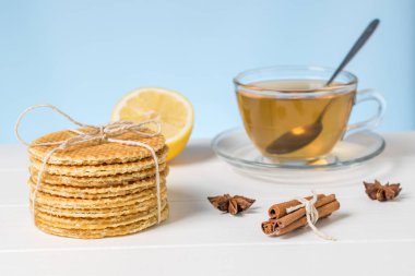 Beyaz bir masada yeşil çay, waffle ve olgun limon..