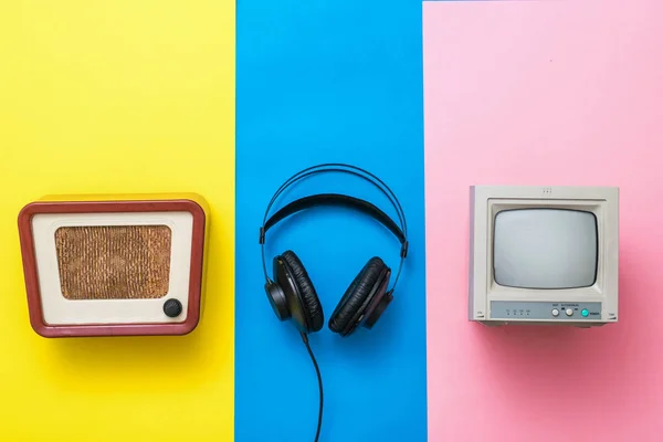 Retroradio, Tv och hörlurar på en trefärgad bakgrund. — Stockfoto