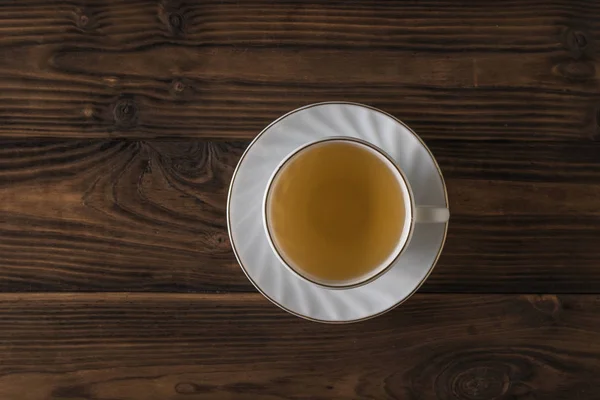 Coupe blanche avec thé vert sur une table en bois. Pose plate . — Photo