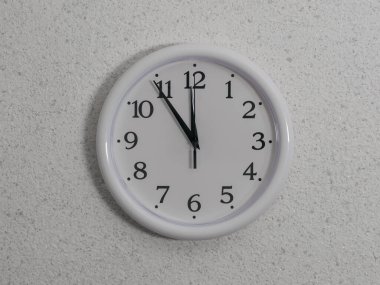 Analog kadranlı bir saat ve ışık duvarında büyük eller..