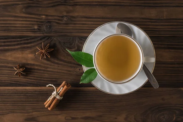 Thé vert à la cannelle sur une table en bois dans une tasse en céramique blanche. La vue du haut . — Photo