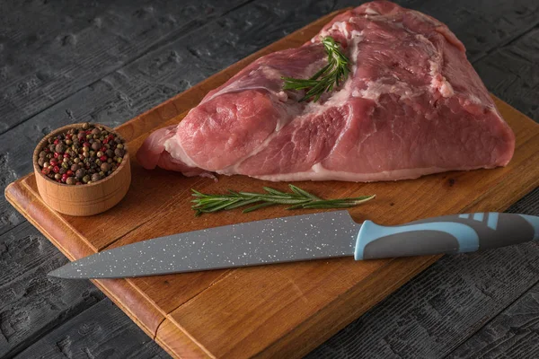 칼 과 양념이 달린 도마 위에 놓인 돼지고기 고기 한 조각. — 스톡 사진