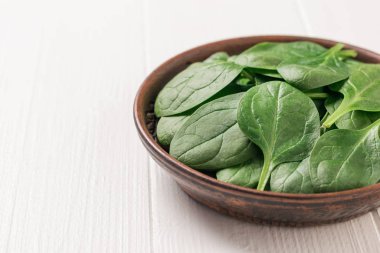 Beyaz bir masada taze toplanmış ıspanak yaprakları. Fitness için yemek. Yukarıdan görünüşü.