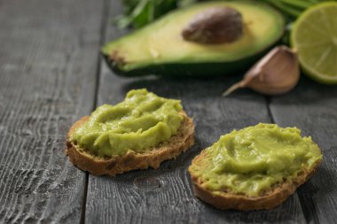 Two slices of bread with avocado and garlic guacamole. Diet vegetarian Mexican food avocado.