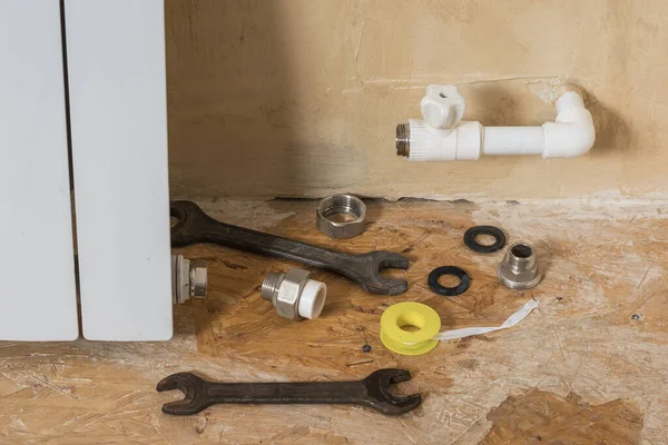 A set of tools and materials for repair near a leaking radiator. Accident of the heating system of a private house. — Stok fotoğraf