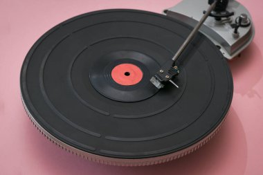 Pembe arka planda klasik plak çalar.