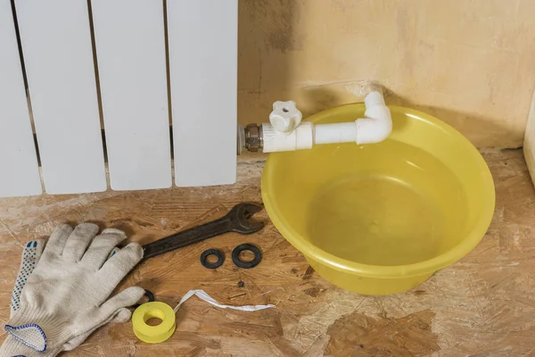 Rękawice i narzędzia naprawcze w pobliżu przeciekającego systemu ogrzewania. Wypadek instalacji grzewczej w domu prywatnym. — Zdjęcie stockowe