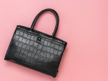 Pembe arka planda klasik deri kadın çantası. Düz yatıyordu.