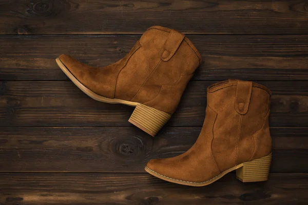 Módní semišové hnědé boty s podpatky na tmavém dřevěném pozadí. Plocha. — Stock fotografie