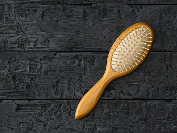 Peine de masaje con asa de madera sobre una mesa de madera . — Foto de Stock