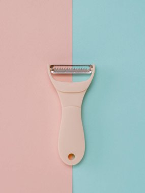 Pembe ve mavi arka planda sebze temizleme aygıtı.