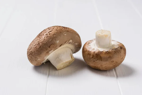 Ein Paar große Royal Pilze auf einem weißen Holztisch. Vegetarisches Essen. — Stockfoto