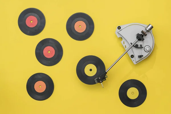 Винтажный проигрыватель пластинок с разноцветными виниловыми дисками на желтом фоне . — стоковое фото