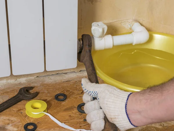 Un homme en gants répare un radiateur . — Photo
