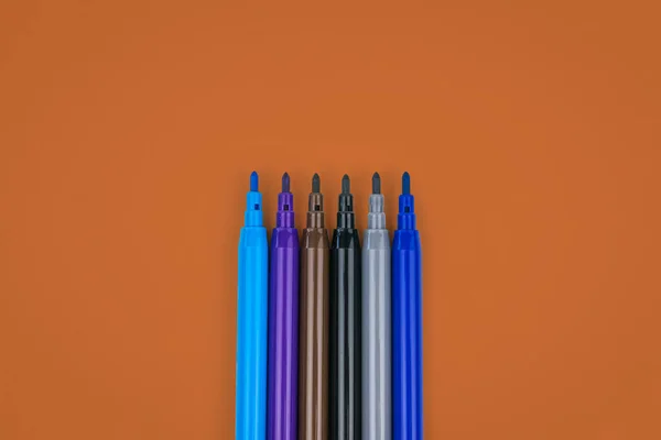 Um conjunto de marcadores de cor legal em um fundo marrom rico . — Fotografia de Stock