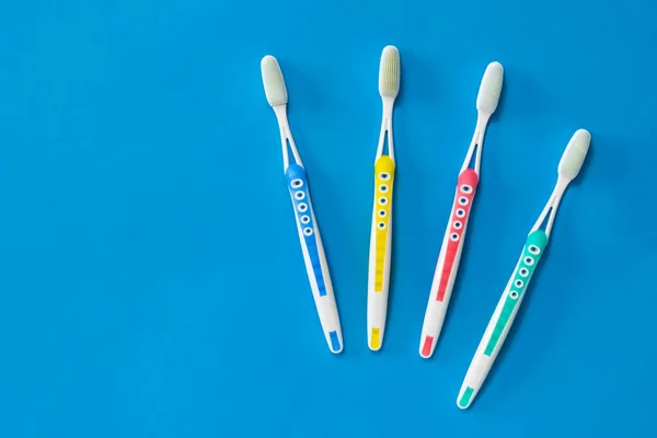 Conjunto familiar de cepillos de dientes con cerdas de silicona sobre fondo azul. Concepto de higiene bucal en la familia . — Foto de Stock