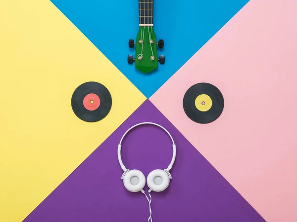 Headphones, guitar and vinyl discs on an abstract background. — Stock Photo, Image