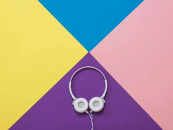 White headphones on an abstract background of four colors. — Stock Photo, Image