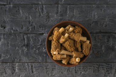 Kil bir kase ve koyu ahşap bir arka planda taze toplanmış moronlar..