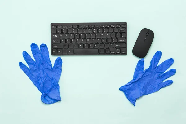 Сині медичні рукавички і чорна клавіатура з мишкою на світлому фоні . — стокове фото