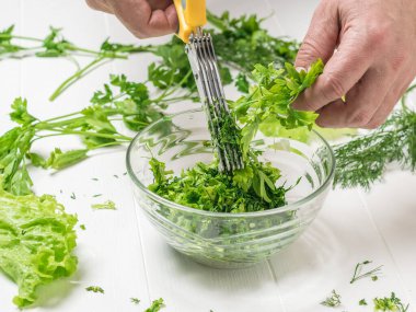 Bir adam salatayı özel bir makasla keser..