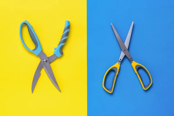 Due forbici da cucina su fondo blu e giallo . — Foto Stock