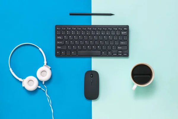 Headphones, coffee, and peripherals on a two-color background.