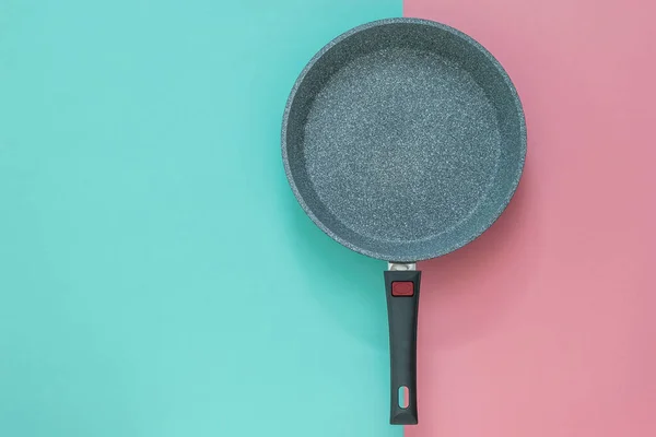 Sartén profunda con asa extraíble sobre fondo rojo y azul . — Foto de Stock