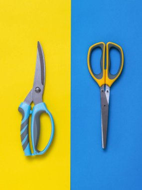 Arka planda iki renkli bir mutfak makası..