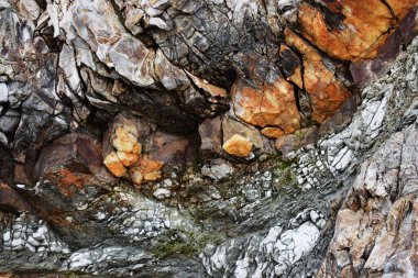 Uçurumun dokusunda karışık renkli taşlar var..