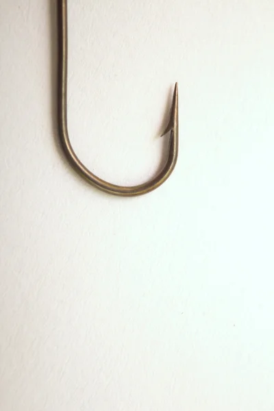 Gancho de pesca sobre un fondo de papel blanco — Foto de Stock