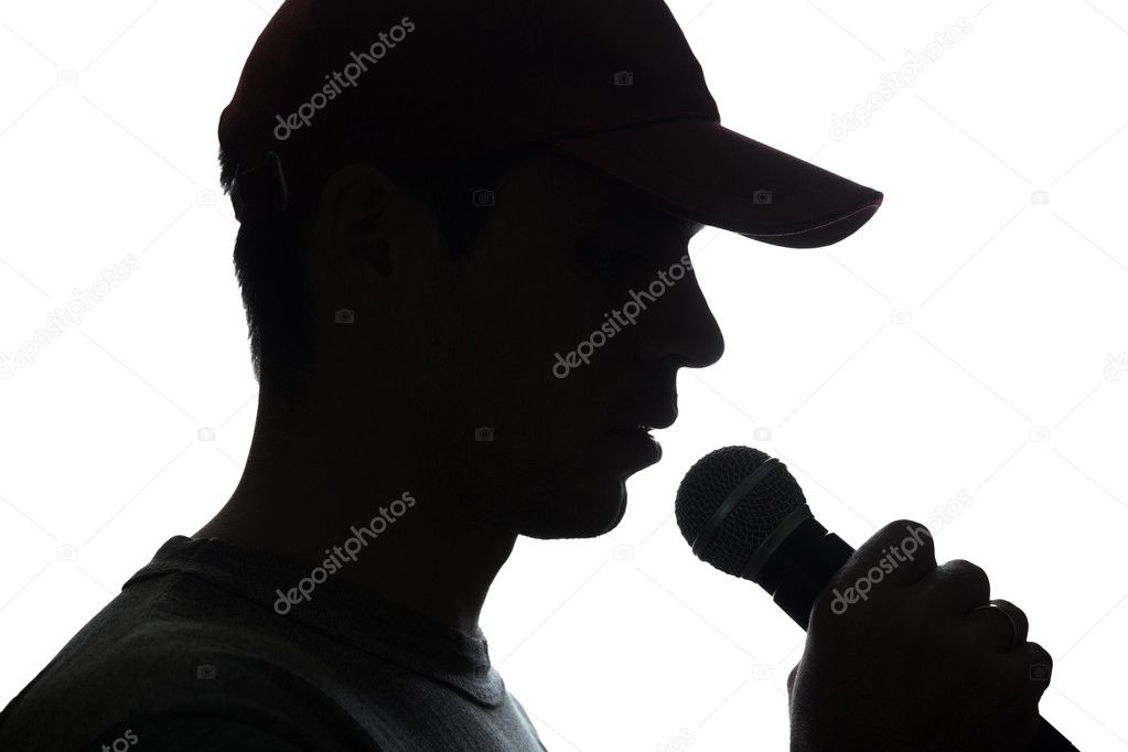 Young man in cap singing into a microphone